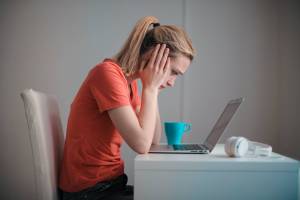 career mistakes woman at computer holding head